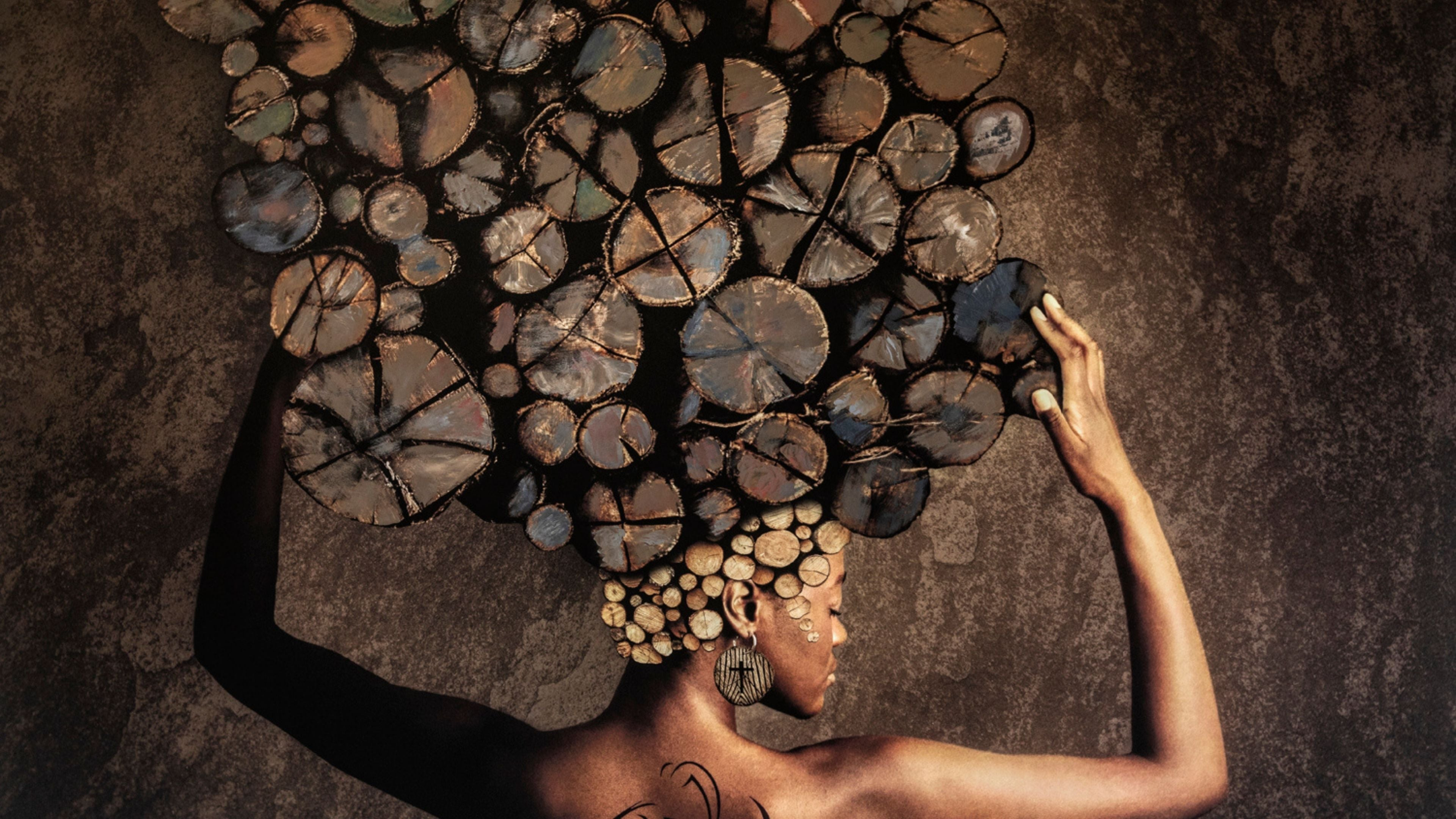 Fine art portrait of an African woman with an elaborate headdress made from painted log cross-sections, blending photography and mixed-media textures