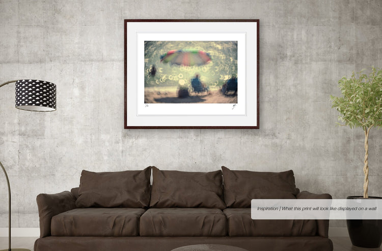 A Man with a Blue Shirt Sitting Under a Pretty Umbrella
